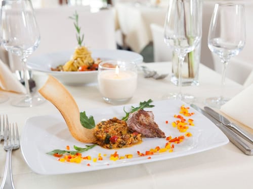 Eingedeckter Tisch mit angerichteten Speisetellern