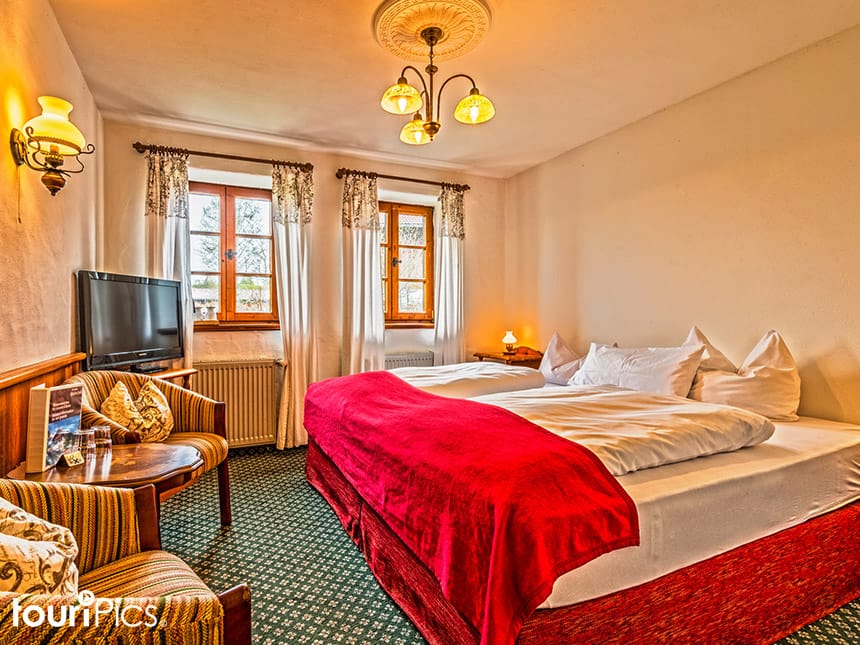 modernes Doppelzimmer mit Sesseln, Tisch und TV