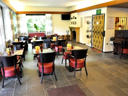 Restaurant mit verschiedenen Tischgruppen und Kamin