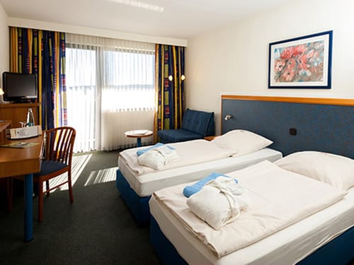 Doppelzimmer mit Twin Bett, Schreibtisch, Stuhl und TV