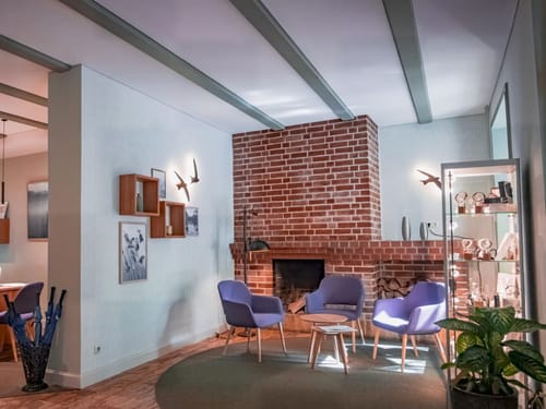 Gemütliche Leseecke mit Kamin und modernen blauen Sesseln