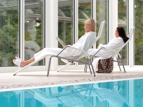 Zwei Frauen auf Liegen im Schwimmbad