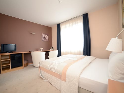 Großes Doppelzimmer mit zwei Sesseln, Schreibtisch und TV