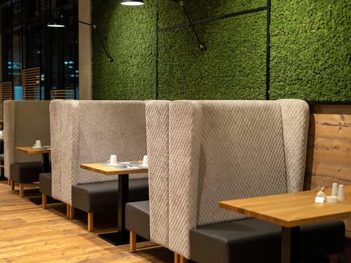 Gemütliche Sitznischen mit Mooswand im Restaurant