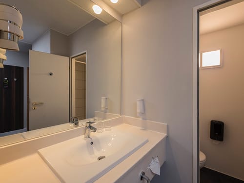 Badbereich mit Waschtisch, Spiegel und WC