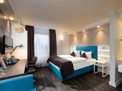 Standard Doppelzimmer mit Twinbett, TV, Schreibtisch, Leselampe und Stuhl