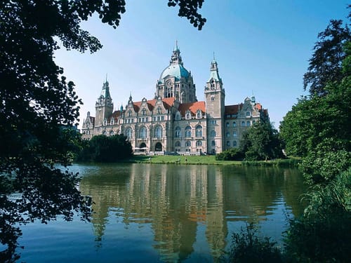 Entdecken Sie das beeindruckende Neue Rathaus in Hannover, ein architektonisches Meisterwerk umgeben von malerischen Gärten und einem glitzernden Teich.