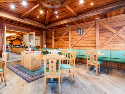Hotelrestaurant mit verschieden Tischgruppen aus Holz und Zugang zum Buffet
