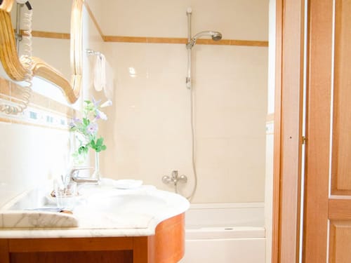 Badbereich mit Badewanne. Wandspiegel und Waschtisch
