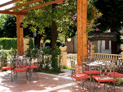 Terrasse bei Sonnenschein mit zwei Tischgruppen