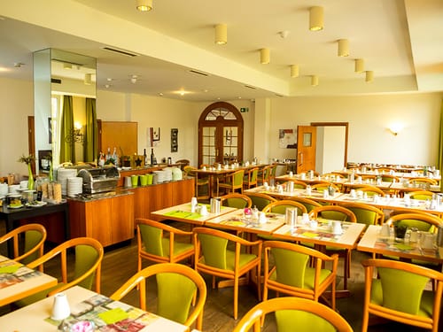 Frühstücksbuffet mit verschiedenen Speisen und Tischgruppen