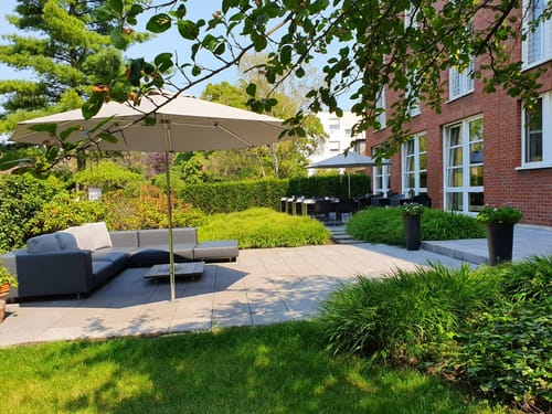 Aussenterrasse mit Loungemöbel und Sonnenschirm