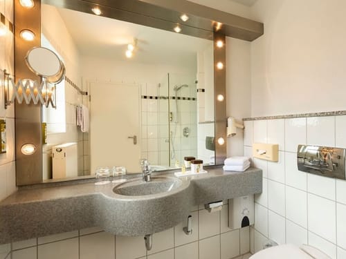 Bad mit Dusche, großem Wandspiegel, Kosmetikspiegel, Waschtisch und Föhn