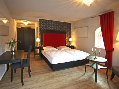 Doppelzimmer mit Boxspringbett, Schreibtisch, Stuhl und Tisch