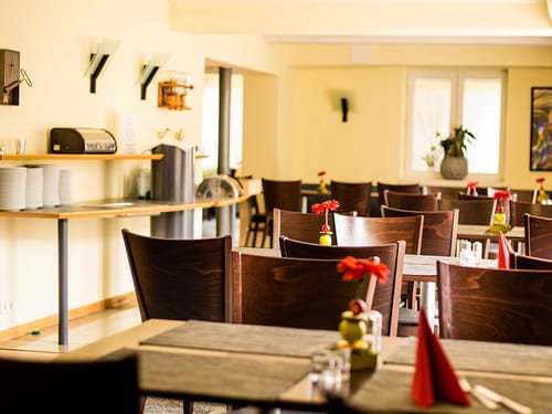 Hotelrestaurant mit verschiedenen Tischgruppen aus Holz