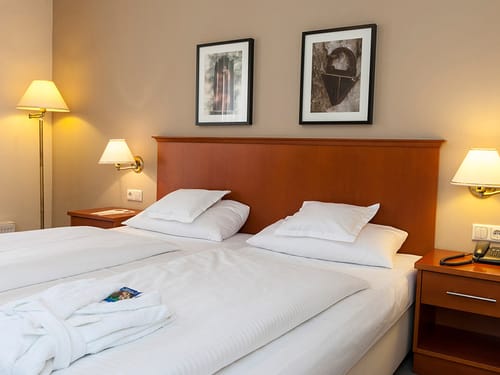Standard Doppelzimmer mit Doppelbett, Nachttischen, Beleuchtung und Telefon