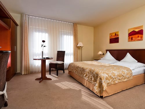 Komfort Doppelzimmer mit Doppelzimmer Tisch, Stuhl, Stehlampe und Wandschrank
