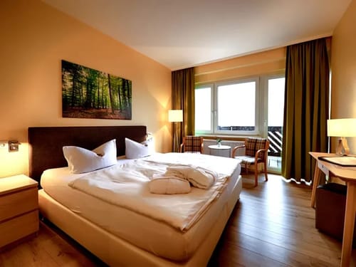 Gemütliches Hotelzimmer mit Doppelbett und Fensterblick