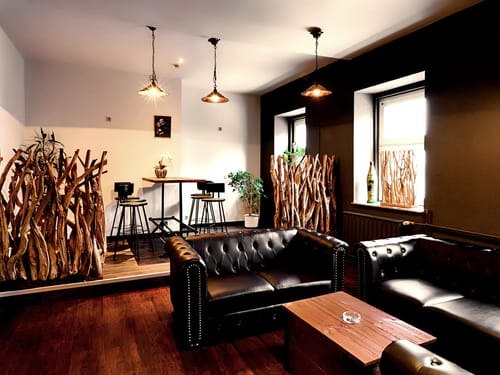 Stilvolles Interieur eines modernen Wohnzimmers mit Chesterfield-Sofas und rustikaler Holzeinrichtung.