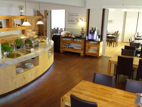 Speisesaal unterteilt in zwei Räumen mit Buffet und verschiedenen Tischgrueppen