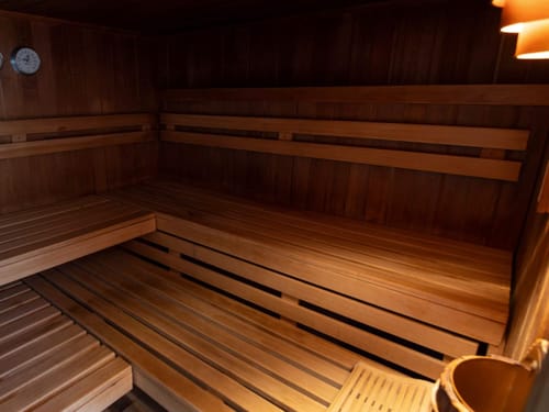 Innenansicht einer traditionellen Holzsauna mit Sitzbaenken.
