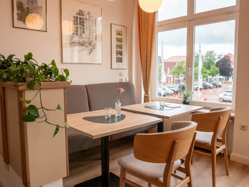 Gemütliches Café-Interieur mit modernen Holzmoebeln und großen Fenstern