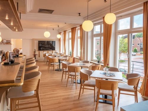 Modernes Café mit stilvoller Einrichtung und großen Fenstern.