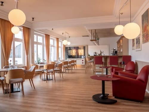 Elegantes Café mit moderner Inneneinrichtung und großen Fenstern