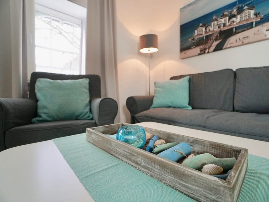 Couch, Sessel, Lampe, Tisch und ein Bild an der Wand