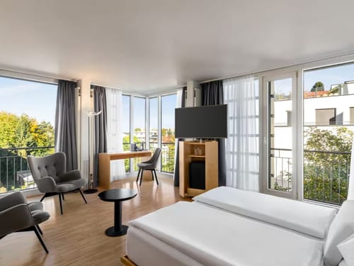 Großes Zimmer mit TV, Schreibtisch, Tisch und zwei Stühlen