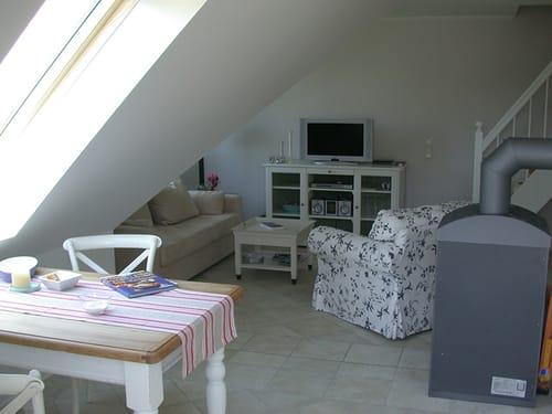 Esstisch, Couch, Sideboard, TV und Kaminofen im Wohnbereich