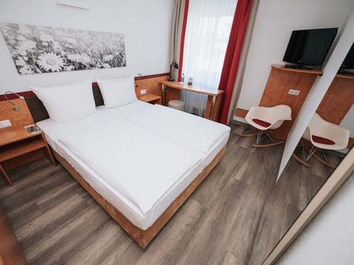 Modernes Hotelzimmer mit Doppelbett und stilvoller Einrichtung