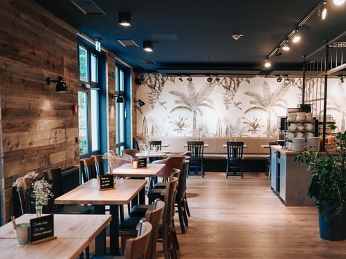 Gemütliches modernes Café mit Holzinterieur und Pflanzenmotiven