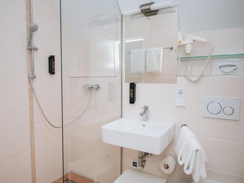 Modernes Badezimmer mit Dusche, Waschbecken und Handtuchhalter.
