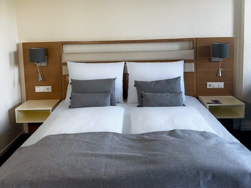 Doppelbett in stilvollem Hotelzimmer mit grauen Akzenten