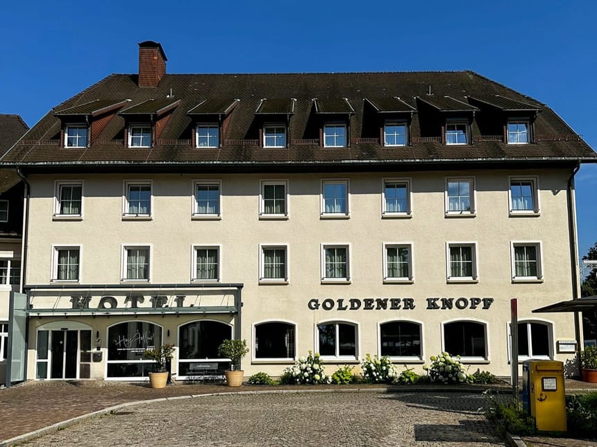 Hotel Goldener Knopf mit klassischer Fassade bei blauem Himmel