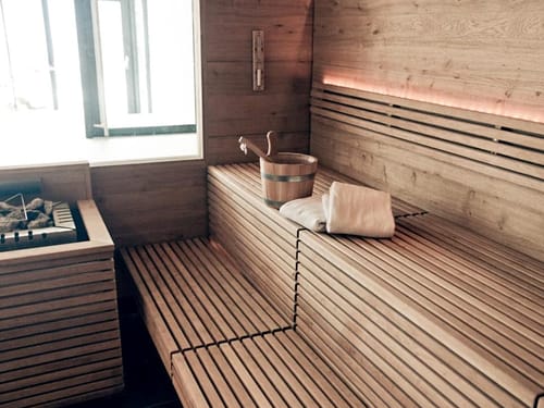 Moderne Sauna mit Holzbänken und Saunaofen