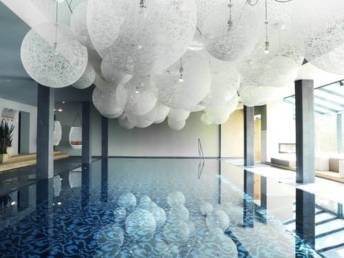 großes Hallenbad mit Lampenschirmen an der Decke