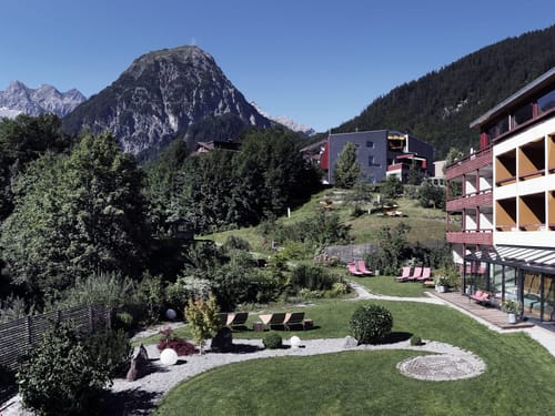 Hotel und Gartenansicht bei Sonnenschein