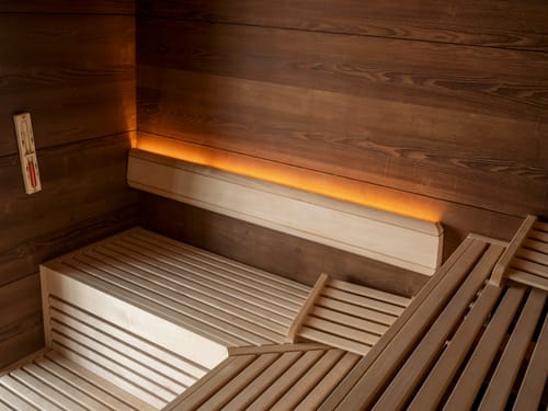Innenansicht einer modernen Sauna aus Holz mit dezenter Beleuchtung