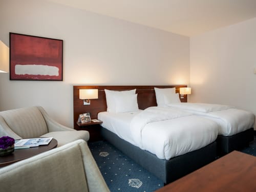 Modernes Hotelzimmer mit zwei Einzelbetten und stilvoller Einrichtung.
