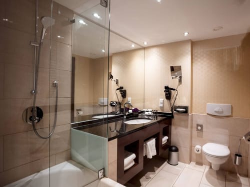 Modernes Badezimmer mit Glasdusche, Waschtisch und WC.