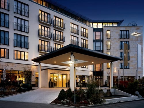 Elegantes Hotelgebäude bei Nacht mit beleuchtetem Eingang.