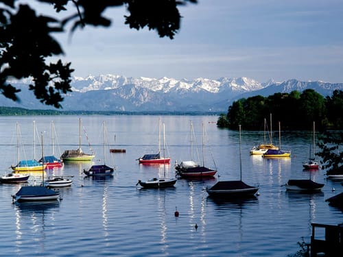 Segelboote auf einem ruhigen See vor einer atemberaubenden Bergkulisse