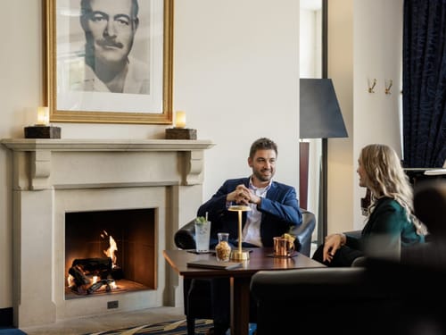 Gemütliche Lounge mit Kamin, zwei Personen im Gespräch