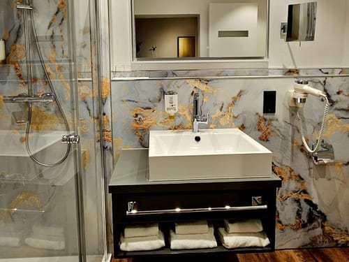 Modernes Badezimmer mit Marmordesign und stilvollen Armaturen.