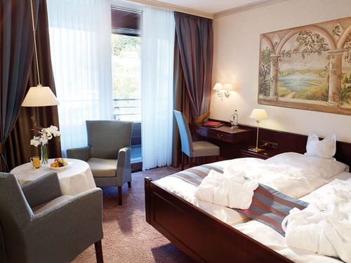 Komfortables Hotelzimmer mit Doppelbett und Sitzbereich