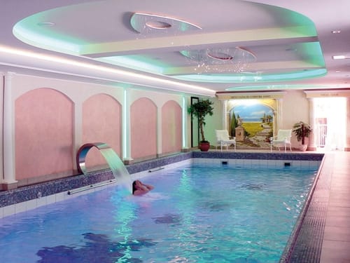 Luxuriöser Innenpool mit Wasserfall im Wellnessbereich