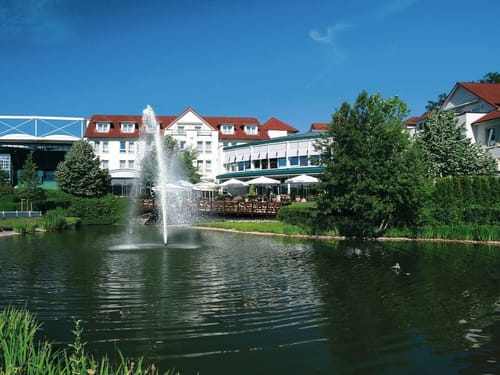 Hotelansicht vom Garten aus mit Blick auf den Teich