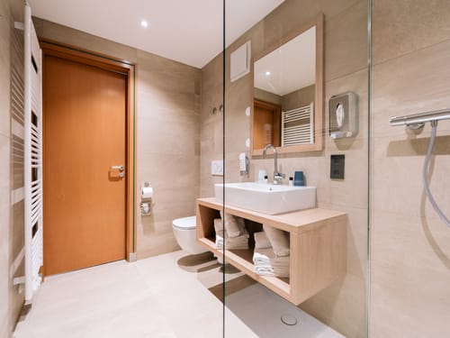 Bad mit Dusche, Wandspiegel, Waschbecken und WC